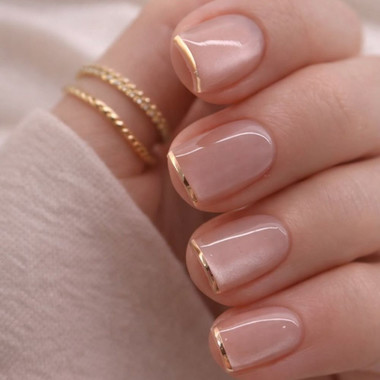Manicure nude ze złotymi liniami i efektem kociego oka