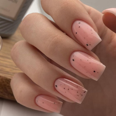 Delikatny nude manicure z czarnymi drobinkami