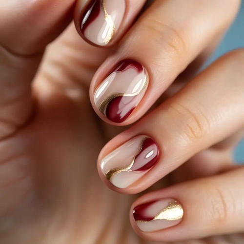Manicure z bordową abstrakcją i złotymi akcentami